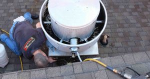 service tech on roof cleaning exhaust