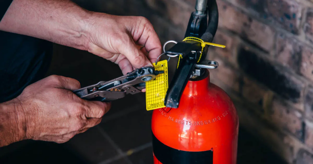 inspection tag on fire extinguisher being marked