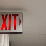 lit exit sign in long hallway