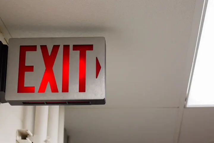 lit exit sign in long hallway